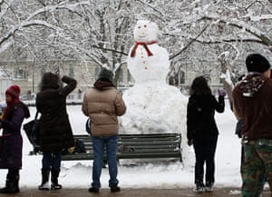 Gallery Snowman gallery: London:  People look at a giant snowman in Kensington Gardens.