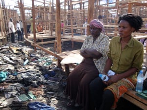 Owino market fire: Women sit the remains of stalls after a fire in a market, Kampala, Uganda.