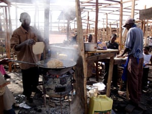 Owino market fire: People cook after a fire in the largest market in Kampala, Uganda.