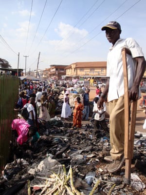 Owino market fire: A man stands on debris after a fire in the largest market, Kampala, Uganda.