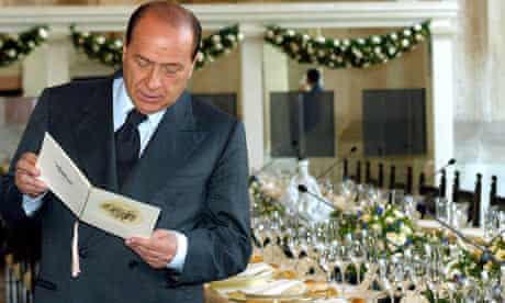 Silvio Berlusconi reads a lunch menu