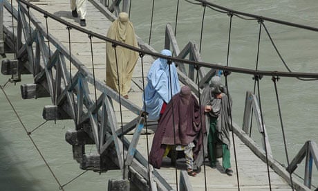 People flee across a bridge in Pakistan's Lower Dir district, where troops are fighting the Taliban