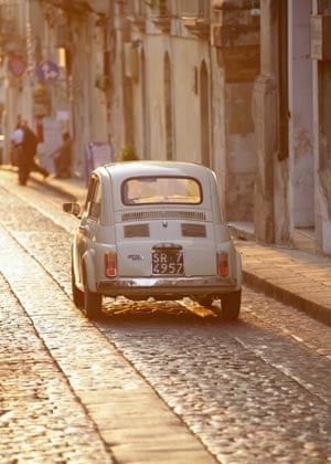 Fiat 500 driving down cobblestone street