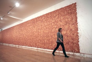 Richard Long: A woman walks past a Richard Long mud painting in the Tate Britain