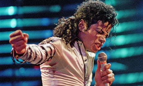 Michael Jackson in white singing into a microphone