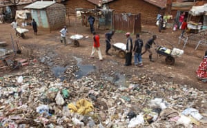 Garbage: Men push goods in the Kibera slum in Nairobi, Keny