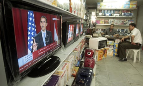 Palestinians watch President Barack Obama's speech in Cairo at a shop in Gaza City.