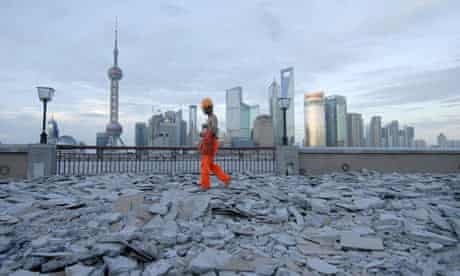 A labourer walks on the bank of the Huang Pu River  in Shanghai, China
