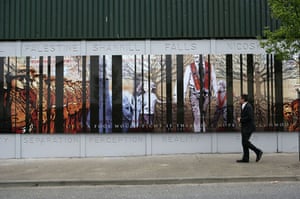 Peace walls in Belfast: A man looks at one of three murals on the loyalist side of the peaceline