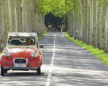 Driving on a tree lined road in France.