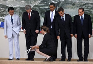 G8 summit: An assistant removes place markers during the G8 group photograph