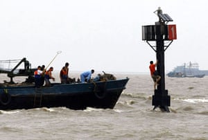 Typhoon Morakot: Shanghai: Rescuers try to reach a man who is stranded by floods