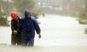 Typhoon Morakot: Wenzhou, China: A couple make their way along a flooded street