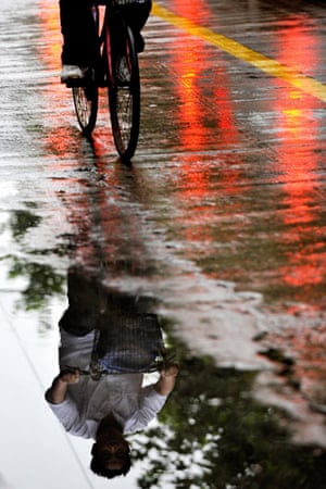 Typhoon Morakot: Shanghai, China: A man riding his bicycle in the rain