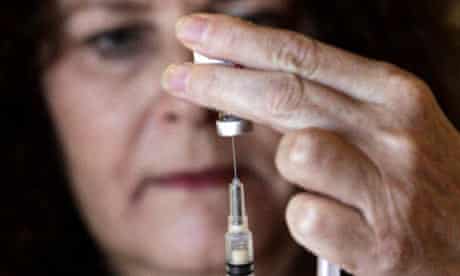 Research nurse drawing swine flu vaccine into syringe