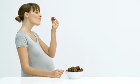 Pregnant woman eating strawberries