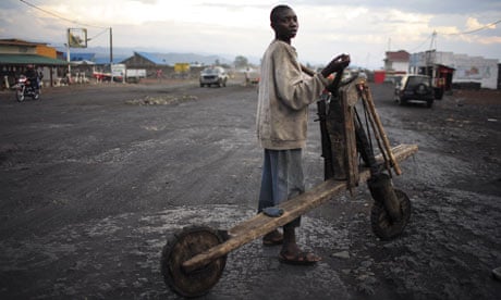 A boy with his wooden bike or chikudu on in Goma, Democratic Republic of Congo