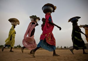 Pictures of the decade: Sudanese women walk to their homes in a refugee camp in eastern Chad