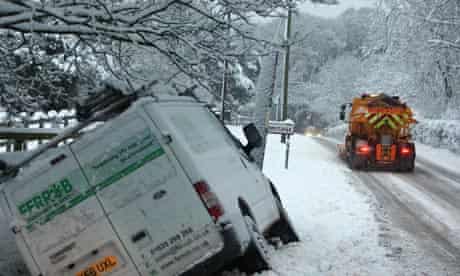A gritting lorry passes a van which has slid off the road near Hermitage in Berkshire