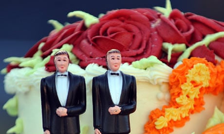 A wedding cake with statuettes of two men