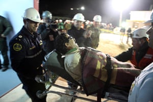 chile miners rescued: Juan Illanes is carried away on a stretcher after being rescued