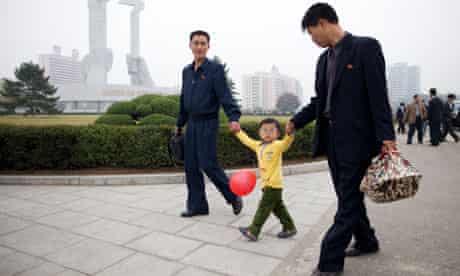 A family passes before the Party Foundation Monunment in Pyongyang.