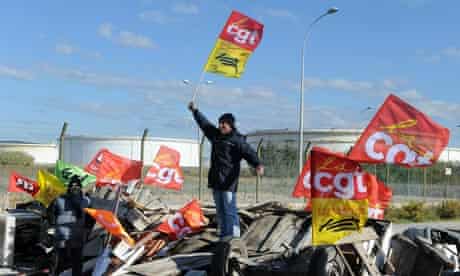 A striker holds a CGT union flag as strikers block fuel storage depots in Frontignan France. 