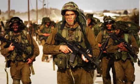 Israeli soldiers walk towards northern Gaza Strip