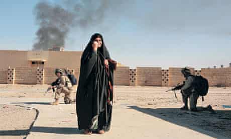 US soldiers crouch behind an Iraqi woman in Ubaydi in November 2005