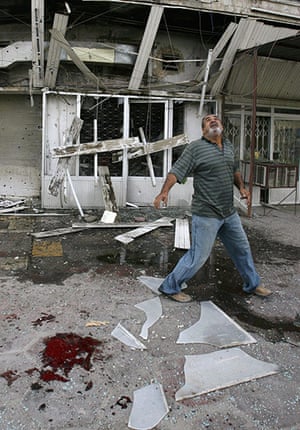 A Day in Iraq: A man walks past the scene of a mortar attack in Baghdad