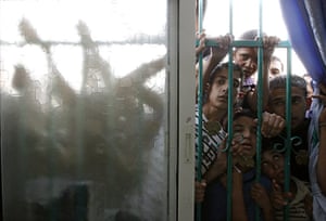 24 hours in pictures: Palestinian youths look through a window before funeral in the West Bank