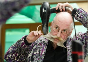 Beard championships: Stefan Bartl from Germany looks into a mirror while styling his beard