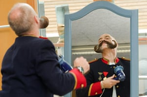 Beard championships: Hans Peter Jahn of Germany looks into a mirror while styling his moustache