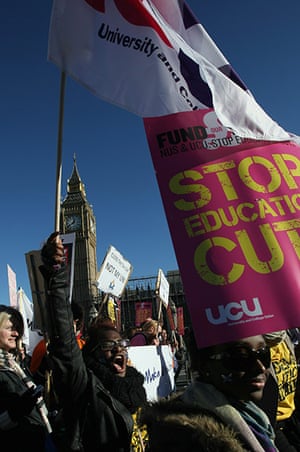 Students protest: Students hold placards as they march past the Houses of Parliament, London