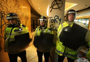 Students protest: Riot police stand guard inside the wrecked entrance to Millbank 