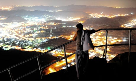 A hajj pilgrim looks at Mecca from the top of Noor mountain