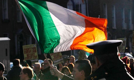 An Irish protester waves a tricolour flag in Dublin during protests against austerity plans