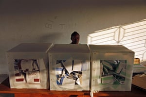 Haiti Elections: An electoral worker waits behind ballot boxes 
