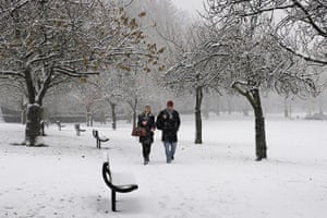 More Snow hits the UK: People walk through a snow covered park in Croydon, south London