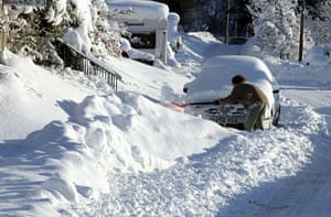 More Snow hits the UK: A person clears snow in Carronbridge, Central Scotland