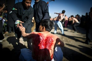 Ashura Religious Festival: An Afghan Shiite Muslim man is comforted after beating himself Ashura