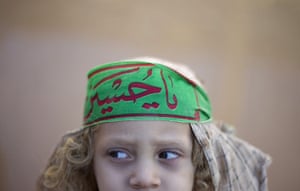 Shia Ashura Update: A young girl wears a symbol of the Imam Hussein family Ashura 