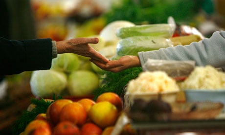 A customer pays after buying produce at a market in Riga, Latvia