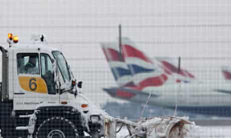 A snow plough is driven by a worker at Heathrow Airport in west London
