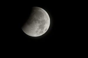 Lunar Eclipse: A total lunar eclipse beginning as the full moon is shadowed by the Earth