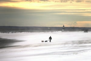 East coast blizzards: A man walks along a beach following a snow storm in Westport, Connecticut