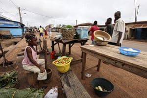 Ivory Coast: A girl crush peppers along a street in Gagnoa