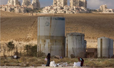 Palestinian women collect scrap timber near the Jewish West Bank settlement of Maaleh Adumim
