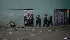 Haiti : Armed policemen stand at a wall during protests