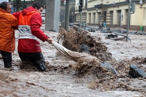 Madeira : A man is helped while trying to cross a flooded street in Funchal 